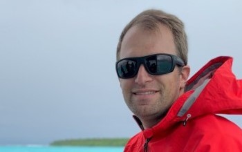 Dr. Daniel Thornhill, GEO RISE Acting Deputy Division Director, sits on boat in ocean.